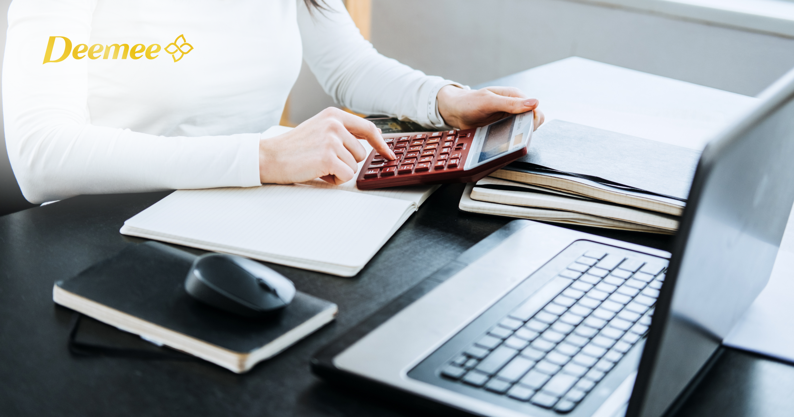 Người phụ nữ ngồi trước laptop, sử dụng máy tính để tính toán chi phí vận hành